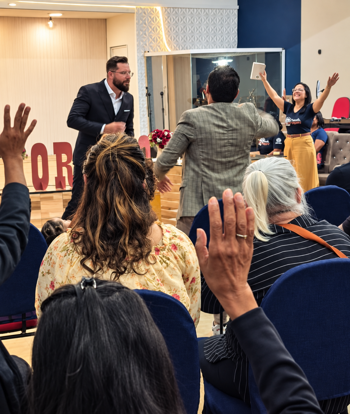 Participantes com as mãos erguidas durante um treinamento conduzido por Daniel Clavem